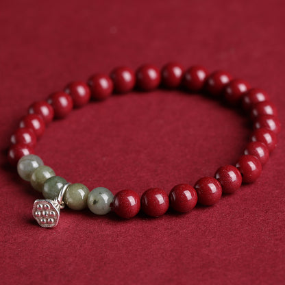 Bracelet en cinabre rouge avec perles de jade vertes et breloque en argent en forme de lotus – Symbole de chance, de prospérité et de sérénité